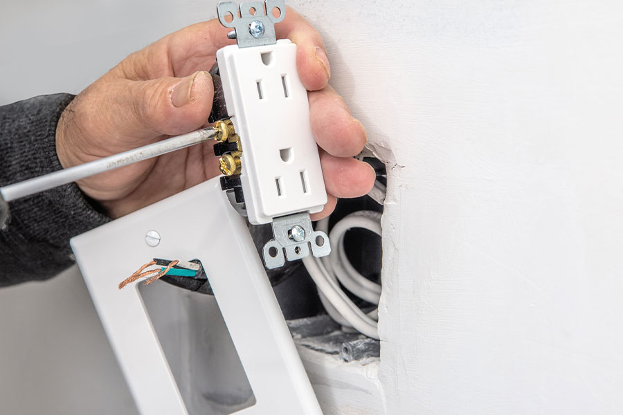 Electrician performing outlet install